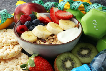muesli with dairy and fruit, healthy lifestyle. bowl of cereal, fruit and dumbbell