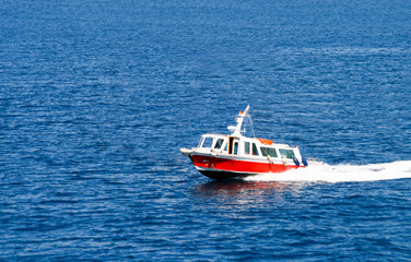 Fototapeta premium Small Red Boat Speeding Across the Mediterranean sea