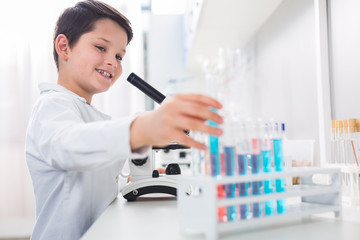 Vigorous enthusiastic boy reaching vial