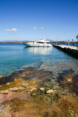 Fototapeta premium Luxury motor boat and the pier in the port of Spetses island, Greece