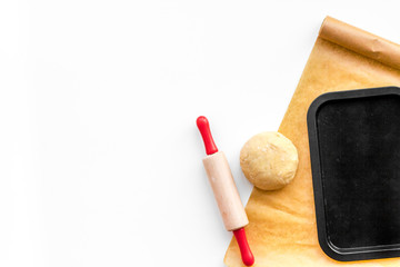 Roll out the dough. Dough ball near roller pin and other cookware on white background top view copy space