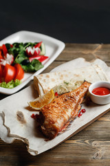 grilled sea bass . Serving on a wooden Board on a rustic table. Barbecue restaurant menu, a series of photos of different meats