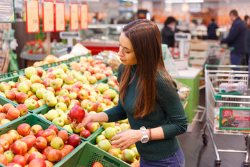 Young woman buy apples in farm food store