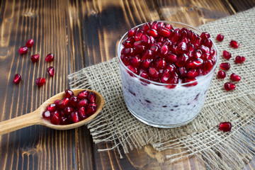 Pudding with chia and garnet on the rustic  wooden background