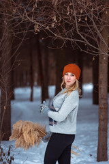 beautiful girl in a fur vest walks in a field in the snow