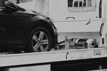 New car transported on tow track in b/w format 