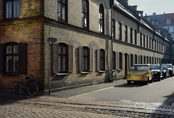 Fototapeta na wymiar Old yellow car in the street on sunny day