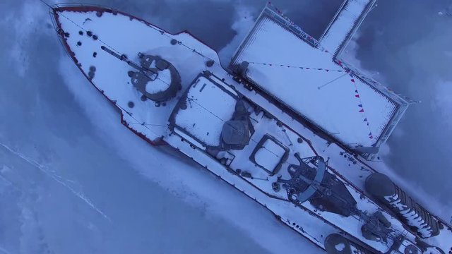 The boat is covered with snow in the ice