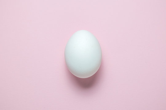 Flat lay of Easter egg on plain pink background