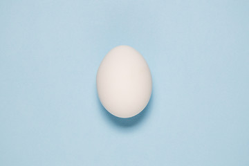Top view of white egg isolated on pale blue background.