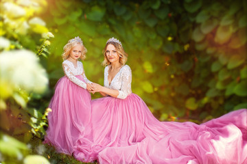 Charming princess in pink dress and tiara on a sunny green park © popovatetiana
