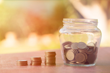 A transparent jar with many coins saved