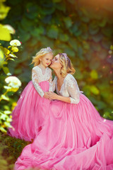 Obraz na płótnie Canvas Loving mother kisses her cheek a little princess in a pink dress