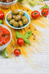 Ingredients for preparation pasta spaghetti - tomato, olive oil, spices, herbs, green olives, tomato sauce