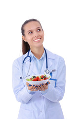 Portrait of a beautiful woman doctor holding a plate with fresh vegetables. Woman doctors.