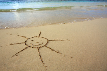 Sun drawing in the sand at the caribbean beach.