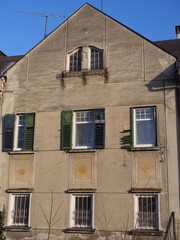 Zahn der Zeit - renovierungsbedürftiges Haus mit kaputten Fensterläden