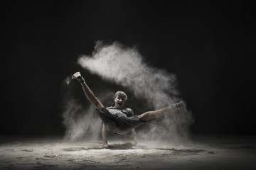 Young men jumping in a cloud of white dust view