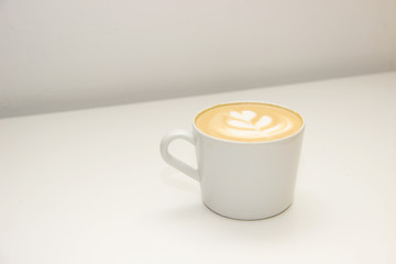 coffee with heart pattern on the foam in white cup