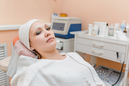 A woman lies on a couch in a cosmetology clinic