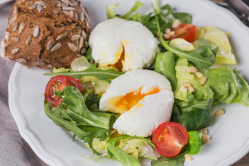 Poached egg with green salad, tomatoes and wholemeal bread