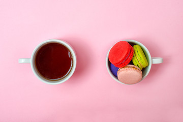 Colorful sweet macaroons and a cup of tea. Delicious breakfast. Top view.	