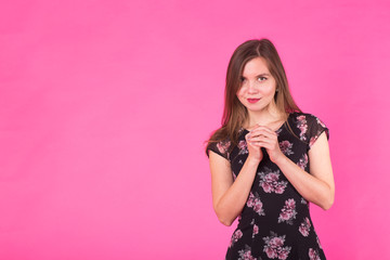Young woman in a dress on a pink background