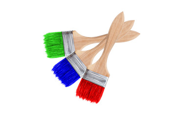 Isolated brushes. Three crossed brushes with red, blue and green paint are isolated on a white...