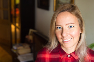 Portrait of a blonde young woman looking at camera in a smiling