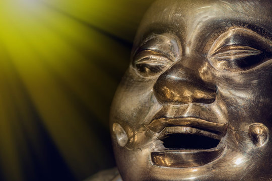 Brass buddha. Happy laughing enlightened monk face