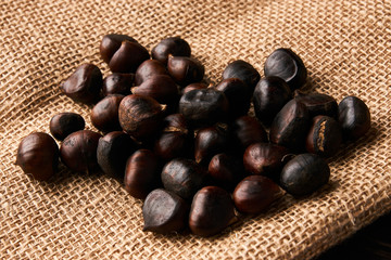 Fresh chestnuts on old wooden table and sack napkin