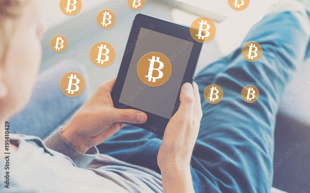 Poster bitcoin with man using a tablet in a chair