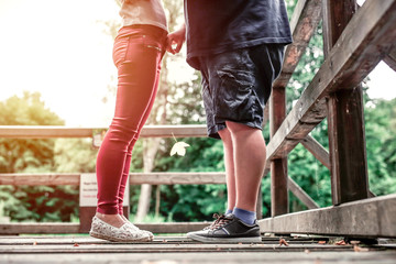 Two young people in love. Cute couple standing together on a wooden bridge