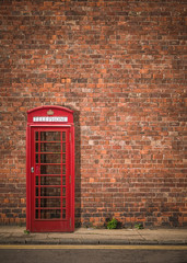 Obraz premium British Phonebox Against Red Brick Wall