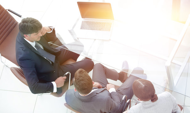 Three Business People, Meeting Around A Boardroom Table