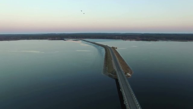 4K Compilation Video. Flight over road in frozen lake in early spring on sunset, aerial view.
