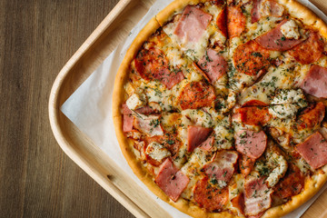 Fresh hot Italian Pizza on wooden table, top view