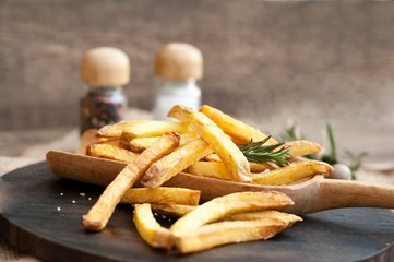 Fast food french fries potatoes with skin served with salt and herbs