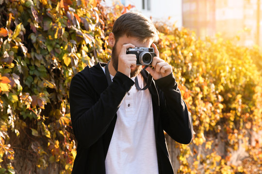 Trendy hipster man taking photo outdoors