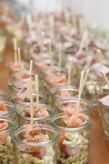 caterer preparing a bunch of glasses with smoked salmon