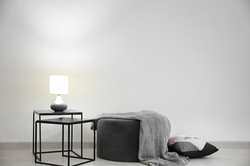 Living room interior with elegant table and pouf near wall