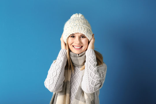 Young woman in warm clothing on color background. Ready for winter vacation