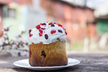 Beautiful Easter cake on a white platter stands on a wooden table
