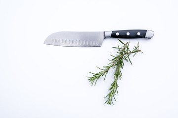 Chef knife and fresh rosemary sprigs on a light background. Great concept for cooking. 