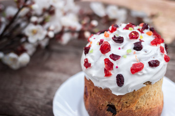 Beautiful Easter cake stands on a wooden surface, in the background the blooming apricot. place under text