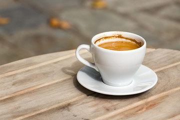 A Greek coffee with plate outdoors.