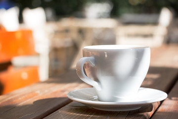 A coffee mug with plate outdoors.