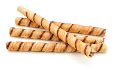 Heap of striped wafer tubules with the chocolate cream, isolated