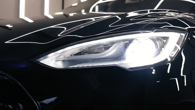 Bumper of a new black car with lights turned on footage.