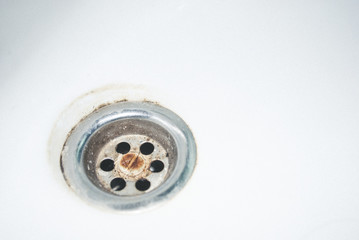 Old used rusty draining point of basin in toilet